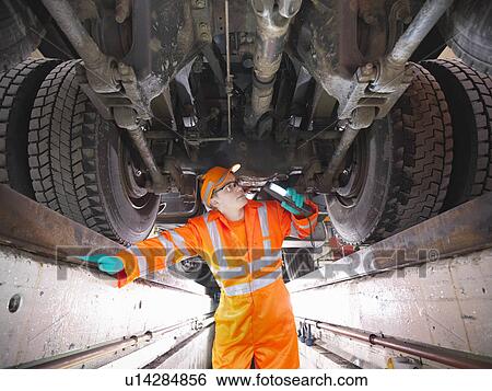 Apprentice engineer examining engine View Large Photo Image Stock Photograph - Apprentice engineer examining engine. Fotosearch