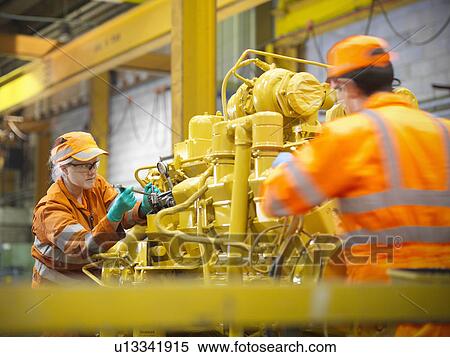 Apprentice engineers at work in factory View Large Photo Image Stock Photography - Apprentice engineers at work in factory. Fotosearch