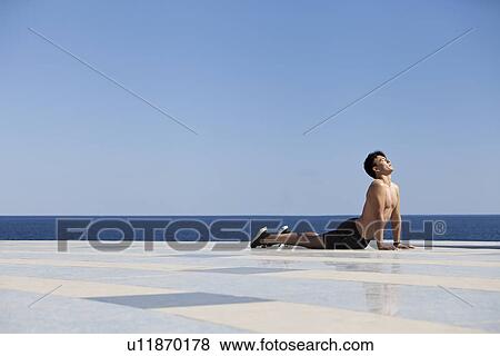 Stock Photo - Athlete practicing yoga on tiled surface. Fotosearch
