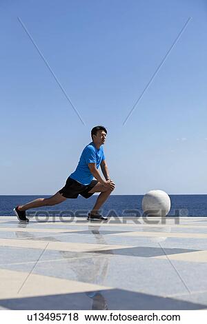 Athlete stretching on tiled surface View Large Photo Image Stock Photo - Athlete stretching on tiled surface. Fotosearch