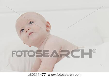 Stock Photo - Baby crawling on bed. Fotosearch