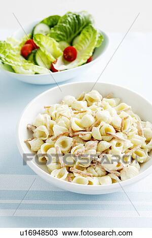 Stock Image - Bowls of pasta and salad. Fotosearch