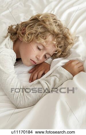 Picture - Boy sleeping on bed. Fotosearch