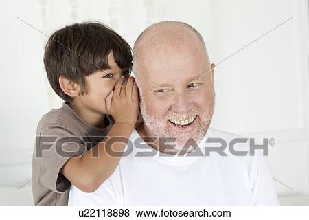 Boy whispering in fathers ear View Large Photo Image Stock Photo - Boy whispering in fathers ear. Fotosearch