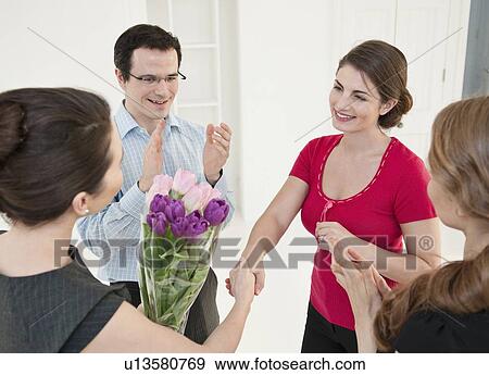 Stock Photo - Business people giving colleague flowers. Fotosearch