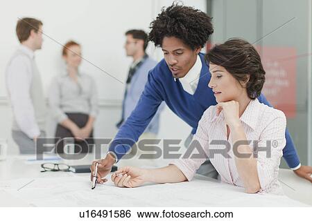 Stock Photograph - Business people reading in meeting. Fotosearch