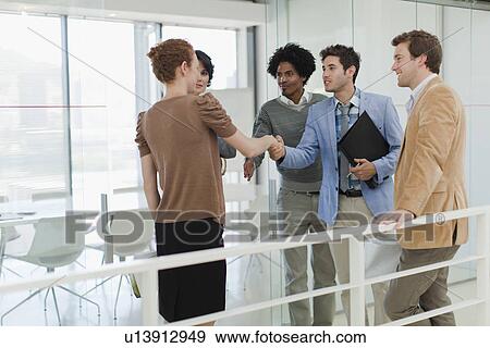 Stock Photo - Business people shaking hands in office. Fotosearch
