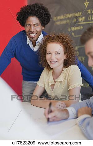Business people smiling in meeting View Large Photo Image Stock Photo - Business people smiling in meeting. Fotosearch