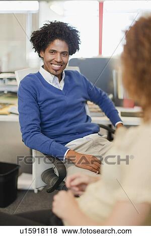 Stock Photo - Business people talking at desks. Fotosearch