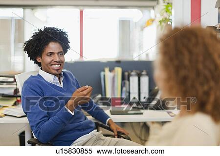 Stock Photography - Business people talking at desks. Fotosearch