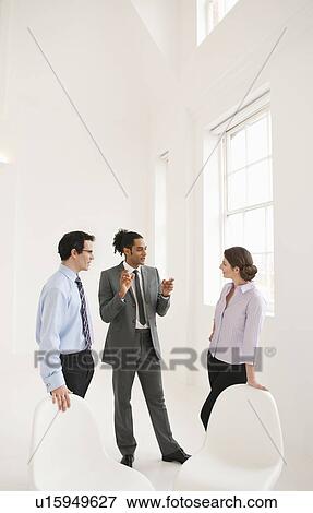 Stock Photo - Business people talking in lobby area. Fotosearch