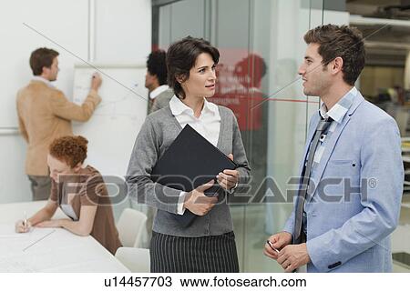 Stock Image - Business people talking in meeting. Fotosearch