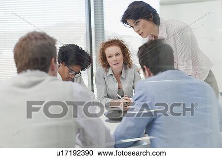 Stock Image - Business people talking in meeting. Fotosearch
