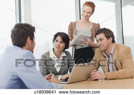 Stock Image - Business people talking in meeting. Fotosearch