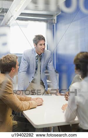 Stock Image - Business people talking in meeting. Fotosearch