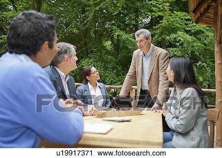 Stock Image - Business people talking in meeting. Fotosearch