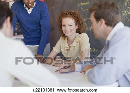 Stock Image - Business people talking in meeting. Fotosearch