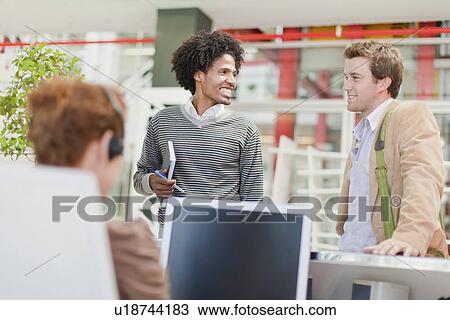 Stock Image - Business people talking in office. Fotosearch