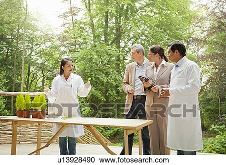 Stock Image - Business people talking with scientists. Fotosearch