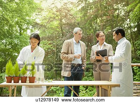 Stock Photo - Business people talking with scientists. Fotosearch