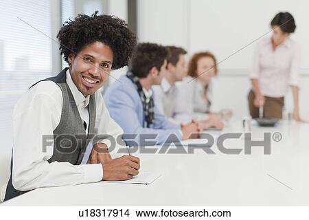 Businessman making notes in meeting View Large Photo Image Picture - Businessman making notes in meeting. Fotosearch