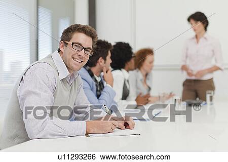 Businessman making notes in meeting View Large Photo Image Stock Photograph - Businessman making notes in meeting. Fotosearch