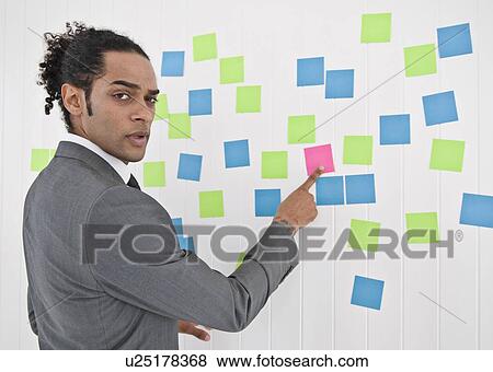 Businessman pointing to sticky note View Large Photo Image Stock Photo - Businessman pointing to sticky note. Fotosearch