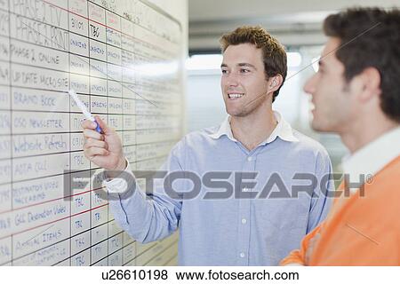 Businessman pointing to whiteboard View Large Photo Image Stock Photo - Businessman pointing to whiteboard. Fotosearch