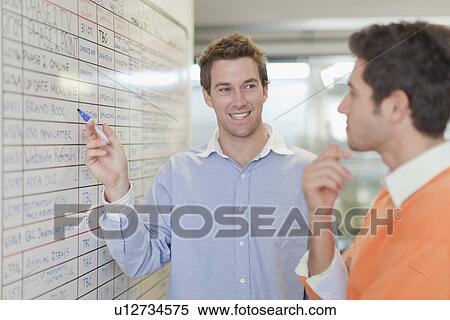 Businessman pointing to whiteboard View Large Photo Image Stock Photography - Businessman pointing to whiteboard. Fotosearch
