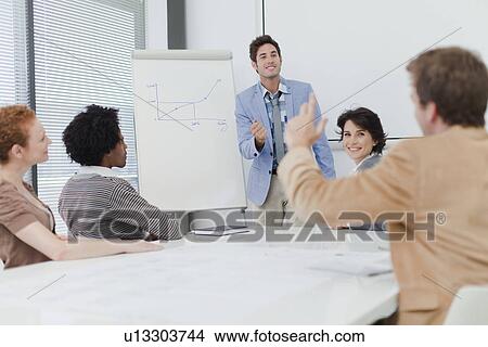 Picture - Businessman raising hand in meeting. Fotosearch