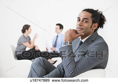 Businessman smiling in lobby area View Large Photo Image Stock Photo - Businessman smiling in lobby area. Fotosearch