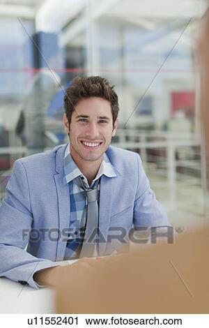 Stock Image - Businessman smiling in meeting. Fotosearch