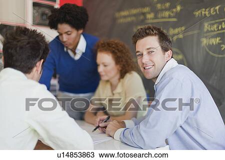 Businessman smiling in meeting View Large Photo Image Stock Image - Businessman smiling in meeting. Fotosearch