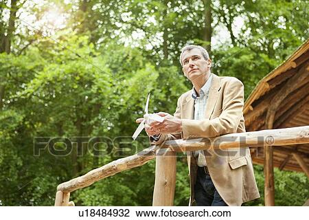 Stock Image - Businessman with propeller on balcony. Fotosearch