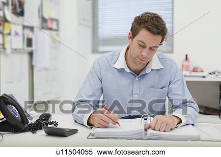 Businessman working at desk View Large Photo Image Stock Photography - Businessman working at desk. Fotosearch