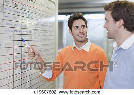 Stock Image - Businessman writing on whiteboard. Fotosearch