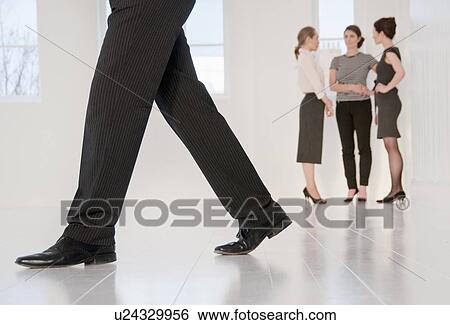 Stock Photograph - Businessmans feet walking in office. Fotosearch