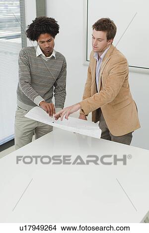 Picture - Businessmen examining blueprints. Fotosearch