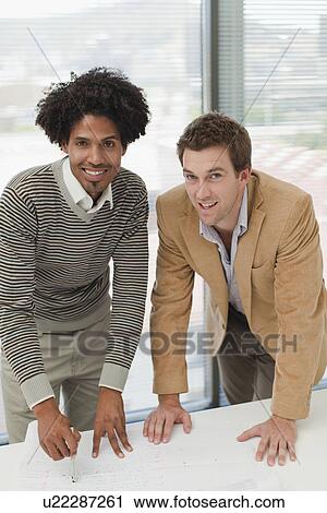Stock Image - Businessmen smiling in meeting. Fotosearch