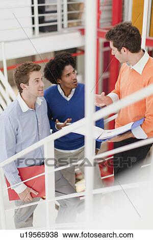 Stock Photo - Businessmen talking in office. Fotosearch