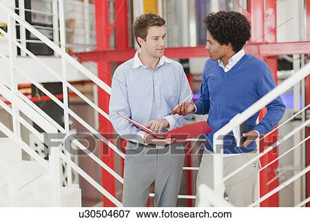 Businessmen talking in office View Large Photo Image Stock Photo - Businessmen talking in office. Fotosearch