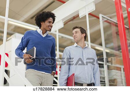 Businessmen walking together in office View Large Photo Image Picture - Businessmen walking together in office. Fotosearch
