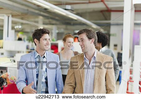 Businessmen walking together in office View Large Photo Image Stock Image - Businessmen walking together in office. Fotosearch
