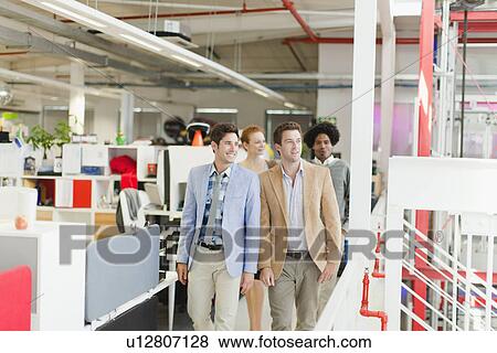 Businessmen walking together in office View Large Photo Image Stock Photo - Businessmen walking together in office. Fotosearch