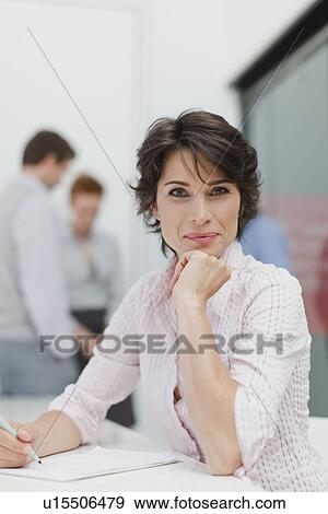 Businesswoman making notes in meeting View Large Photo Image Stock Photo - Businesswoman making notes in meeting. Fotosearch