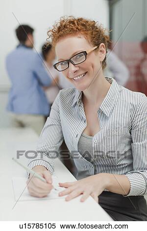 Businesswoman making notes in meeting View Large Photo Image Stock Photography - Businesswoman making notes in meeting. Fotosearch
