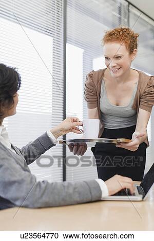 Businesswoman offering cup of coffee View Large Photo Image Stock Image - Businesswoman offering cup of coffee. Fotosearch