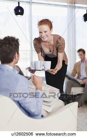 Businesswoman offering cups of coffee View Large Photo Image Stock Photograph - Businesswoman offering cups of coffee. Fotosearch