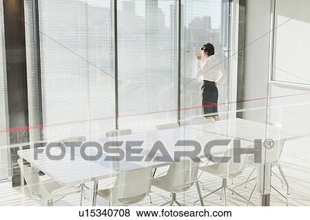 Businesswoman peering out window View Large Photo Image Stock Photo - Businesswoman peering out window. Fotosearch