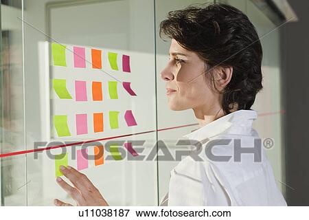 Stock Photo - Businesswoman reading sticky notes. Fotosearch
